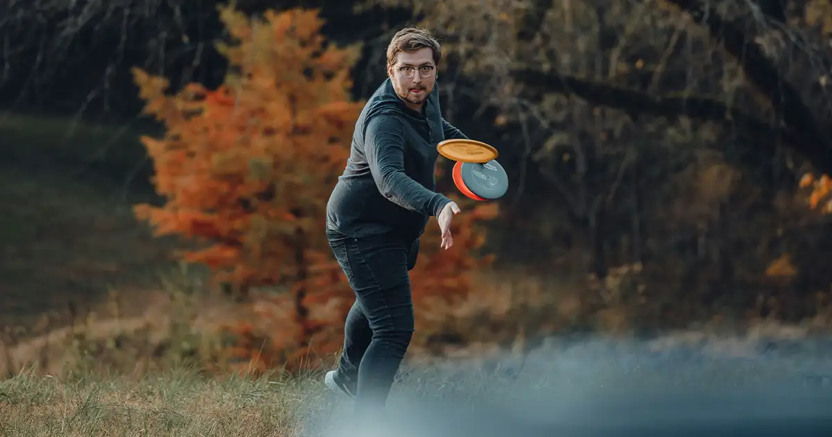 A man playing disc golf with the Innova disc golf starter set